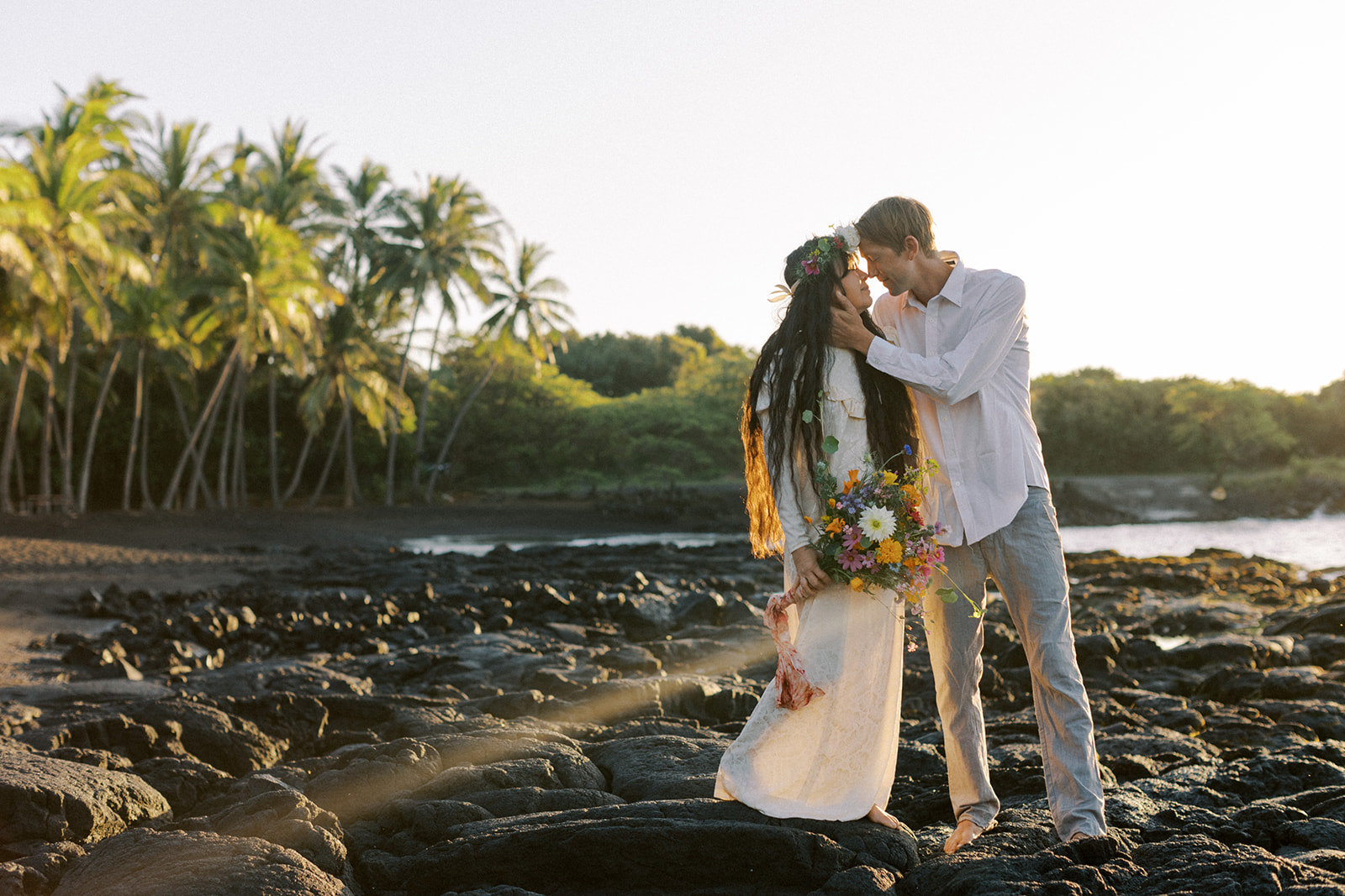 Punalu'u elopement photo with the coconut trees and black sand in the background.